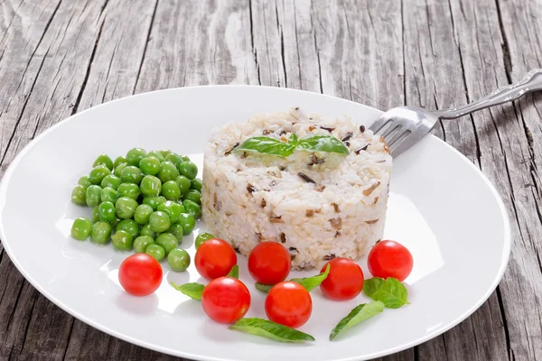Brown and wild rice with cherry tomatoes, green peas