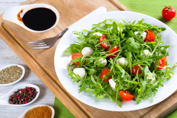 Salad with tomatoes, mini mozzarella, arugula, close-up