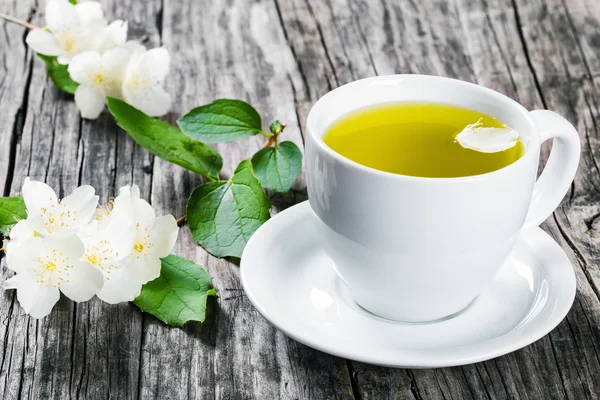 A cup of jasmine tea  with jasmine flowers , close-up