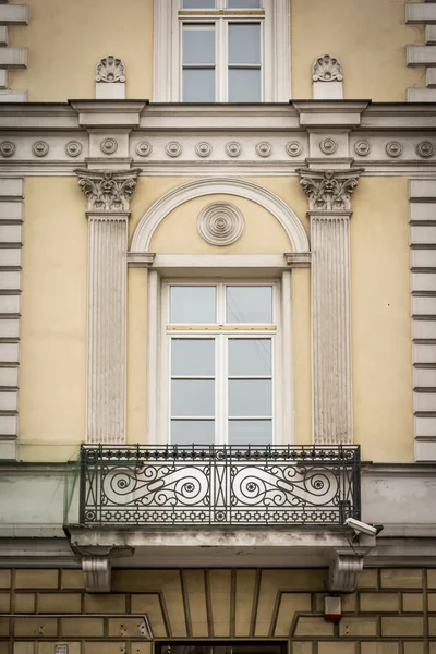 Balcony window in the old residential building with yellow wall and white decor in Warsaw, Poland
