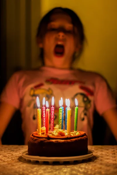 Child birthday blows out the candles on the cake