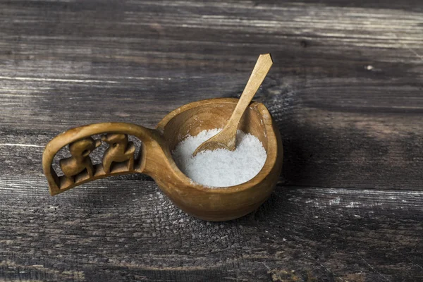 Salt in salt cellar and spoon on a wood table