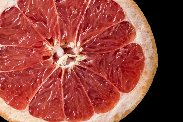 Background of ripe grapefruit Slice on black, fresh fruit texture closeup