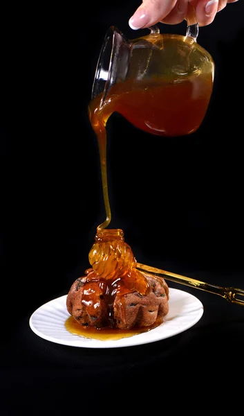 Cake drizzled with honey on a black background