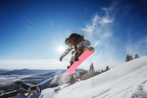 Snowboarder jumps on mountains