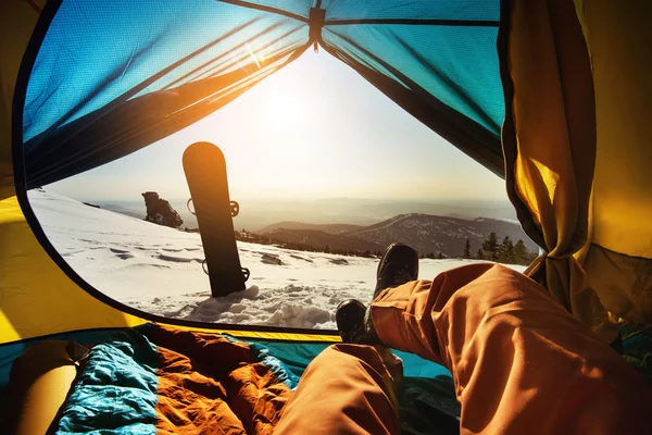 Snowboarder having rest in tent