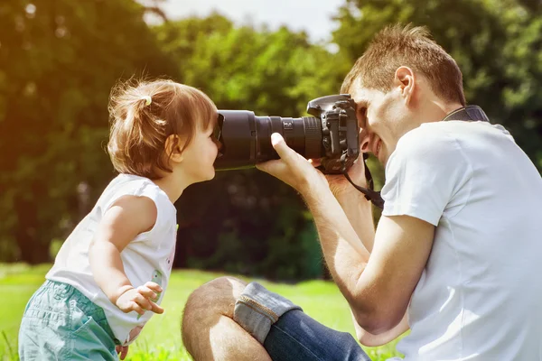 Happy father making photo of daughter