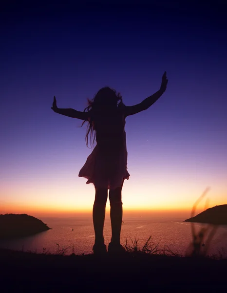 Silhouette of happy child girl stands