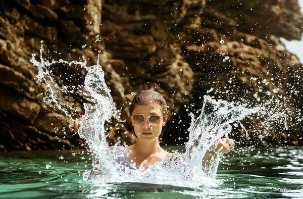 Girl in sunglasses makes splashes