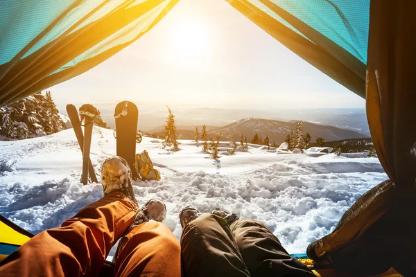 Snowboarder with skier in tent