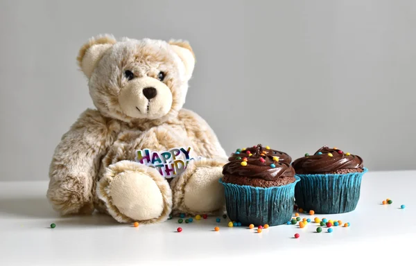 Homemade chocolate cupcake with sprinkles on wooden table mini bear for birthday.