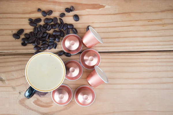 Cup of espresso with espresso  capsule and coffee beans.