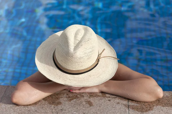 Girl in a pool wearing the hat