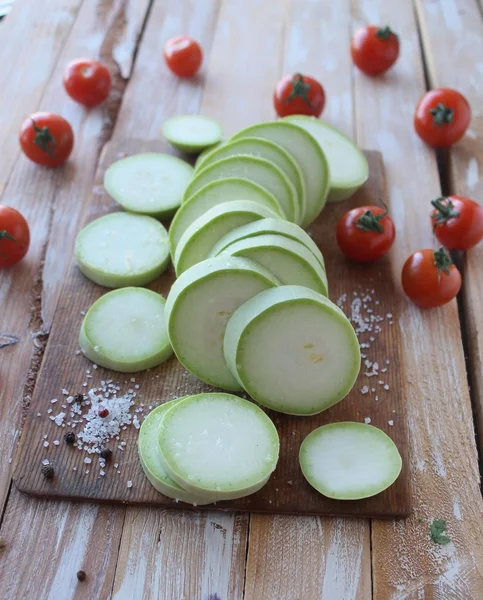 Zucchini slices around the cherry tomatoes and salt