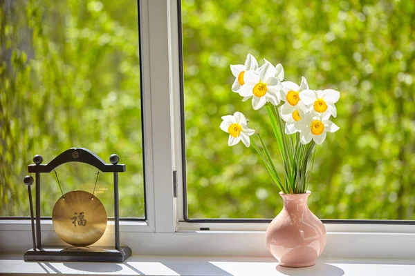 Flowers, daffodils on the window, greens