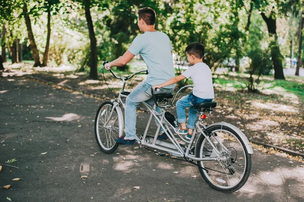 Father and son riding tandem bicycle