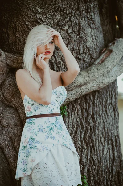Model poses near old tree