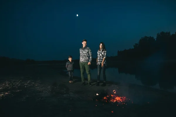 Happy young family near campfire