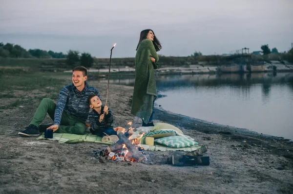 Happy young family near campfire