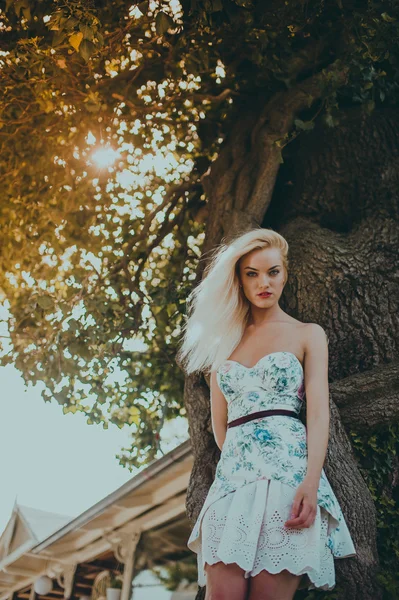 Model poses near old tree