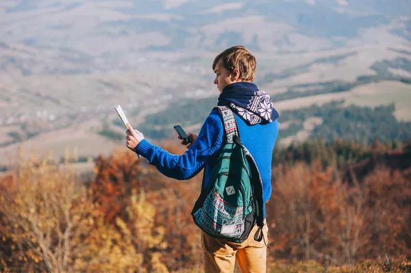 Fellow tourist with map and phone in hands