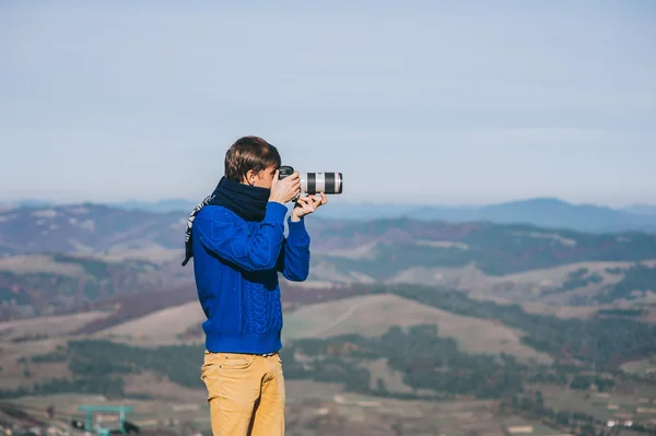 Man with a camera at the edge of a cliff
