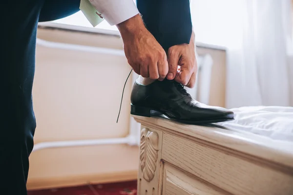 Groom tying shoelaces