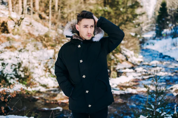 Guy model posing near waterfall