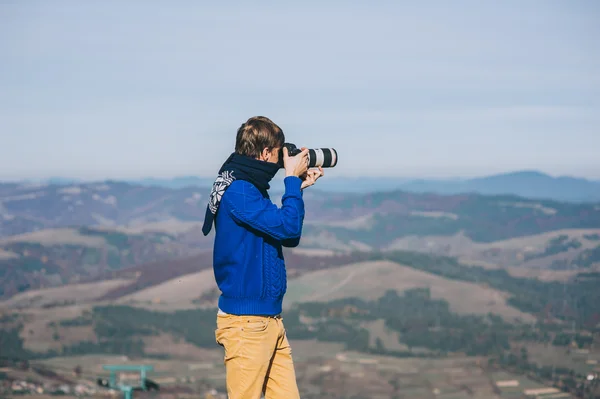Man with a camera at the edge of a cliff
