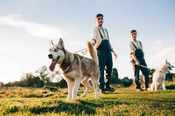 Two twin brothers with husky dogs