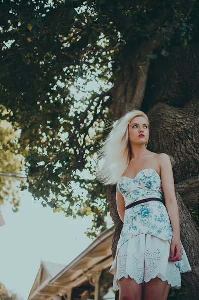 Model poses near old tree