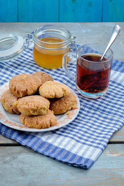 Tea, honey and honey cookies on wooden table