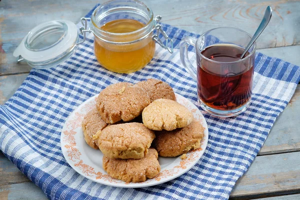 Tea, honey and honey cookies on wooden table