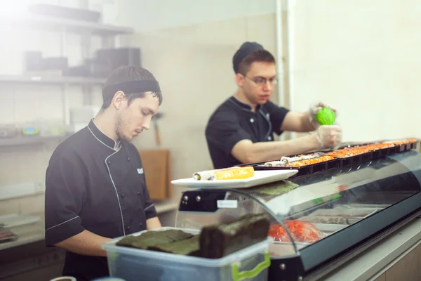 Male cooks preparing sushi in the restaurant kitchen