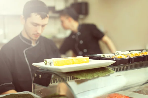 Male cooks preparing sushi in the restaurant kitchen