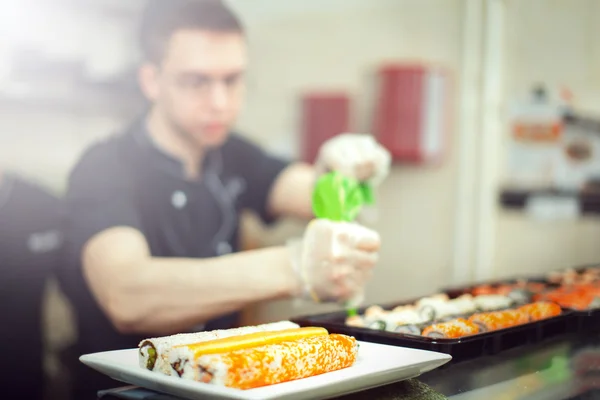 Male cooks preparing sushi in the restaurant kitchen