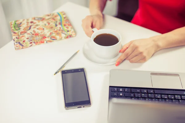 Beautiful  woman using  laptop, phone at table in cafe