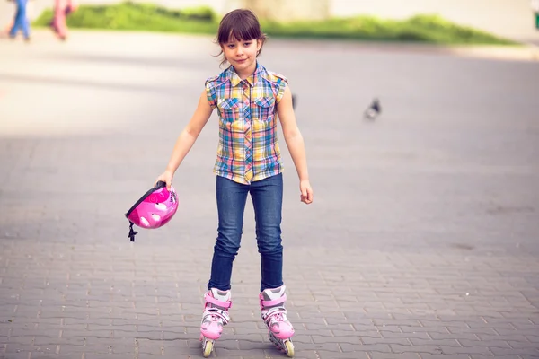 Girl wearing roller skates sitting on grass in the park