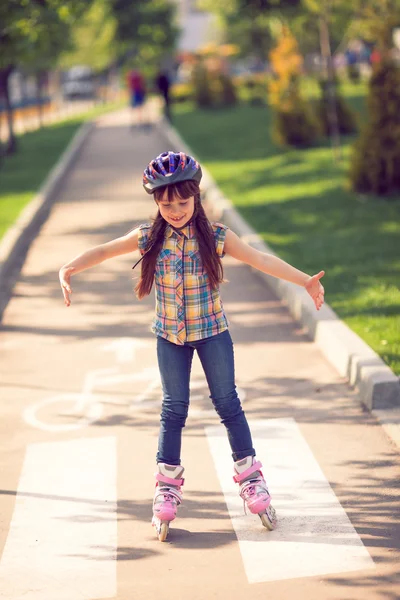 Attractive teenage girl roller skating in the park