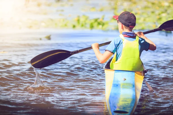 Young people are kayaking on a river in beautiful nature.