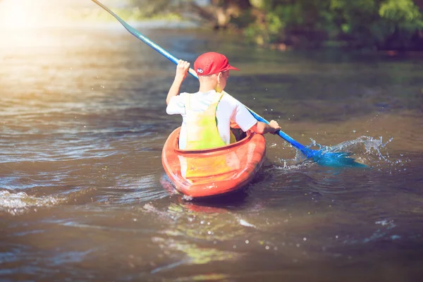 Young people are kayaking on a river in beautiful nature.