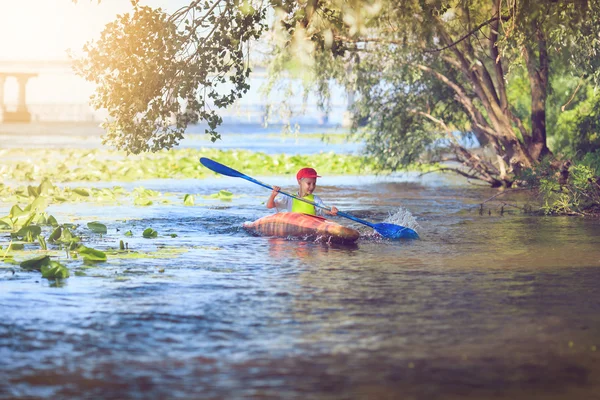 Young people are kayaking on a river in beautiful nature.