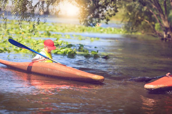 Young people are kayaking on a river in beautiful nature.