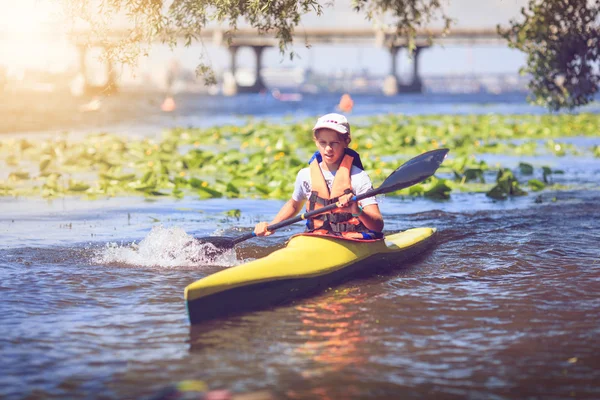 Young people are kayaking on a river in beautiful nature.