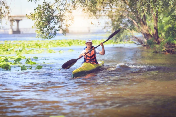 Young people are kayaking on a river in beautiful nature.