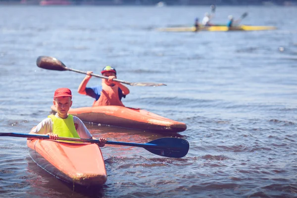 Young people are kayaking on a river in beautiful nature.