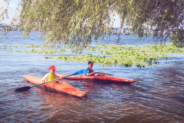 Young people are kayaking on a river in beautiful nature.