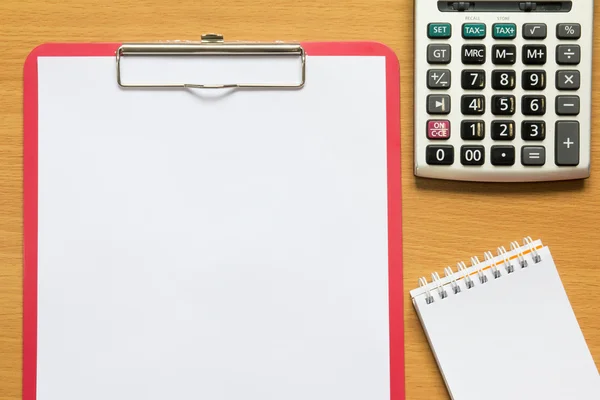Paper in red file, calculator and paper note on wooden table