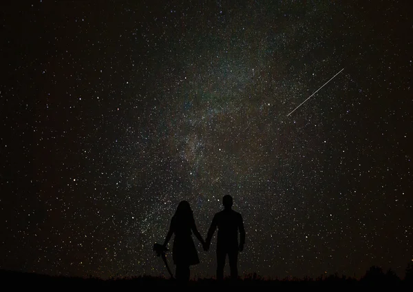 Silhouette of boy and girl on a background stars.
