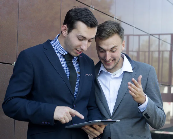 Two businessman looking at tablet. The success of the work of professionals.